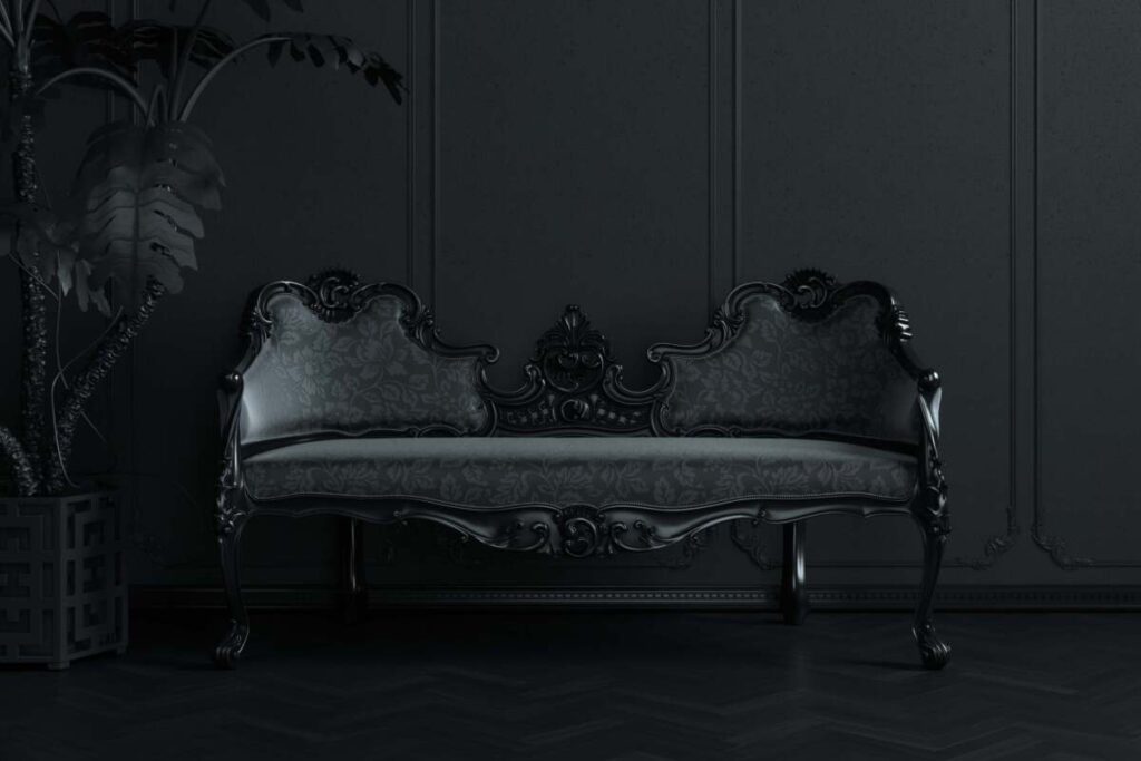 Black Victorian style couch for gothic home decor with a black wall and black plant.