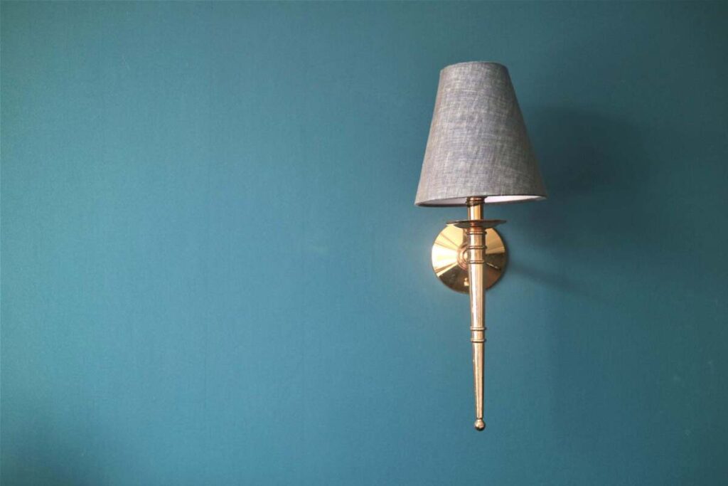 A wall sconce on a green wall