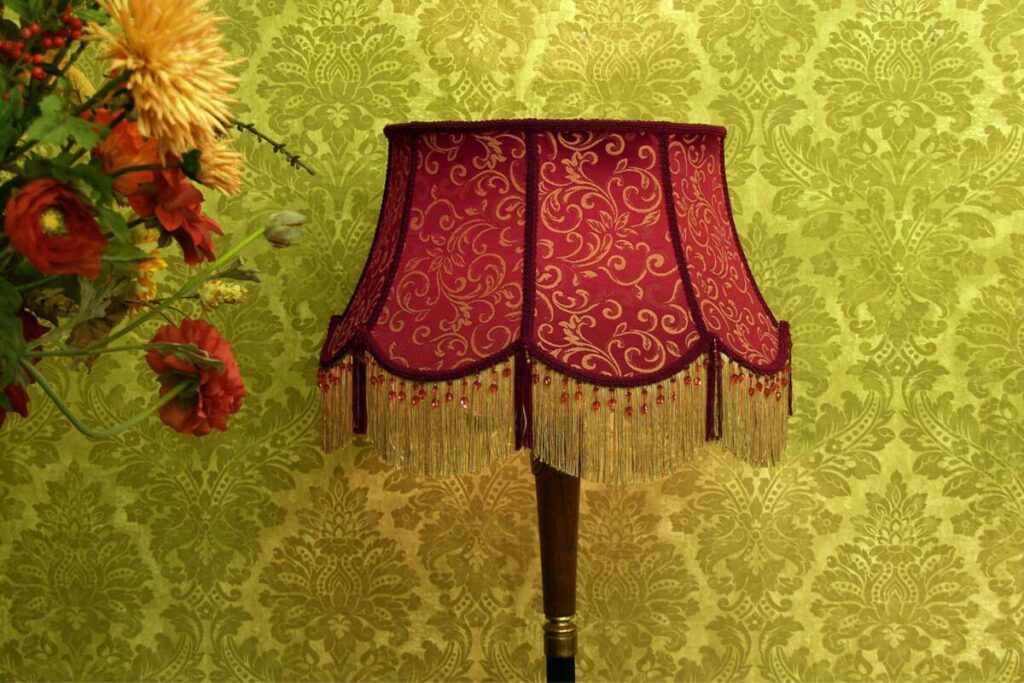 lamp with red cover and yellow wallpaper behind it