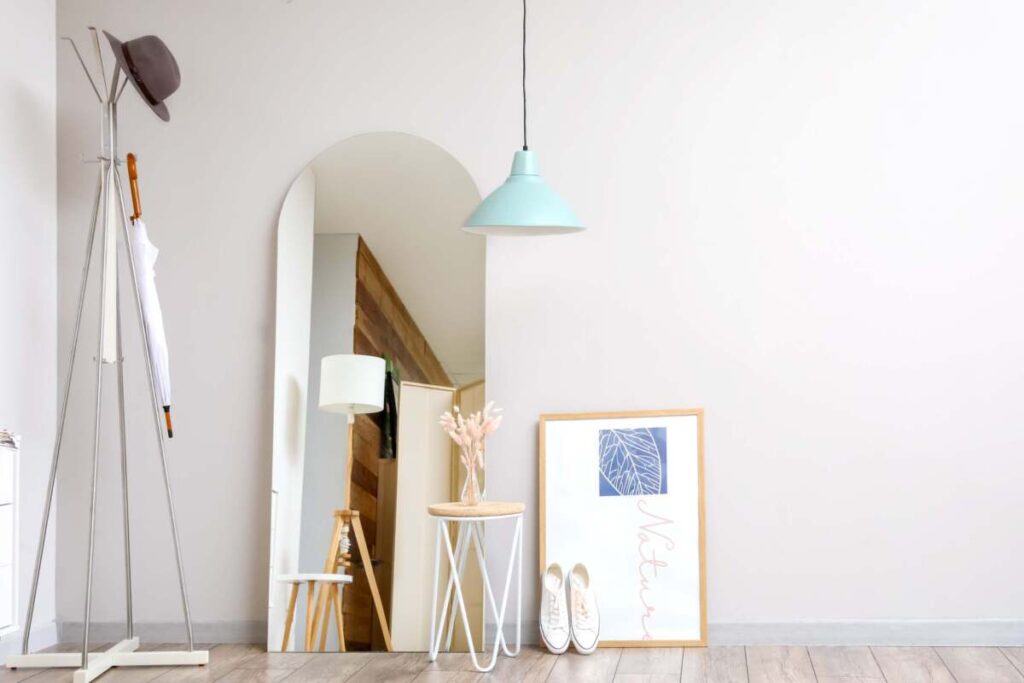 entryway with floor mirror and blue pendant light