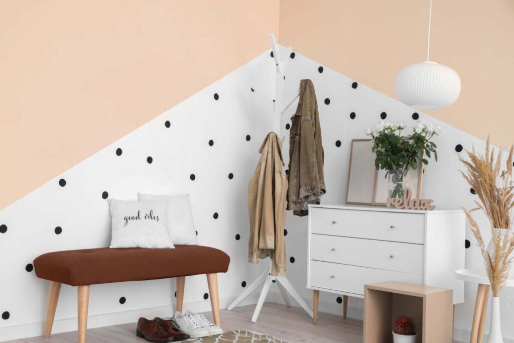 entryway with white dresser, brown bench, coat rack and a white round paper lamp