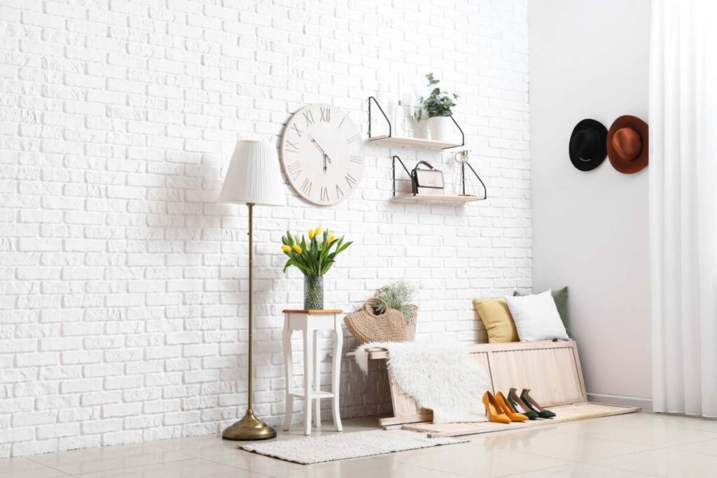 entryway with brick wall and floor lamp