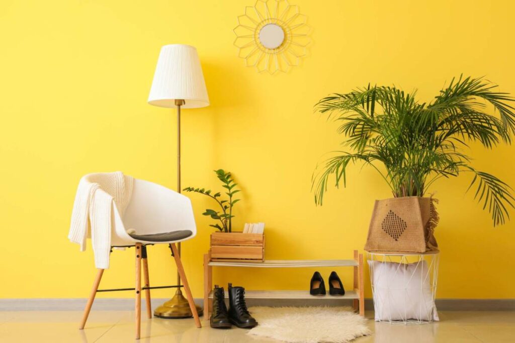 entranceway with a yellow background, chair and a floor lamp