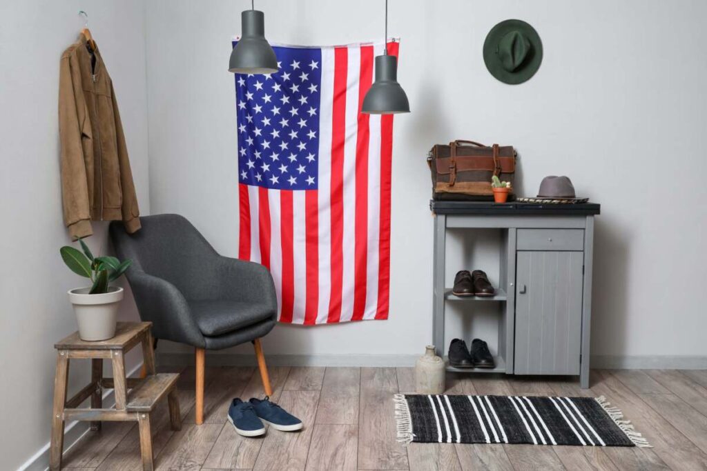 entryway with a black chair, American flag hanging and a grey table