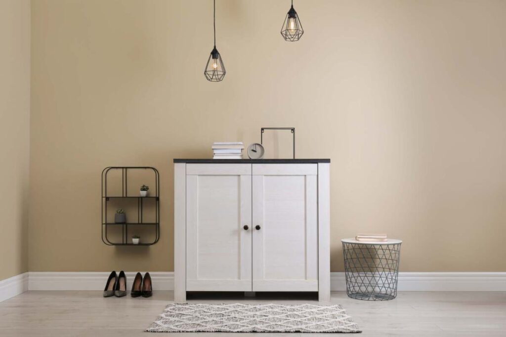 entryway with white dresser and two hanging pendants