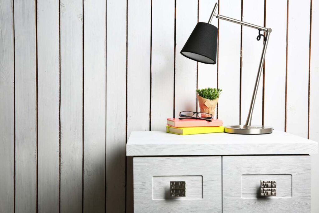 entryway with a white dresser and a table office lamp