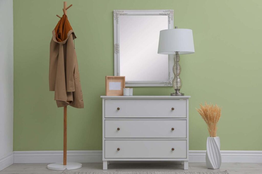 entryway with a grey dresser, rectangular mirror, and table lamp
